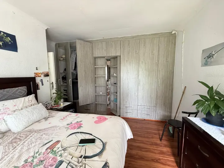 Bedroom with full-height oak-look built-in cupboards