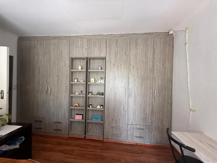 Floor-to-ceiling built-in cupboards with central display shelves