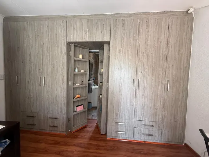 Full-wall built-in cupboards with a hidden shelving door