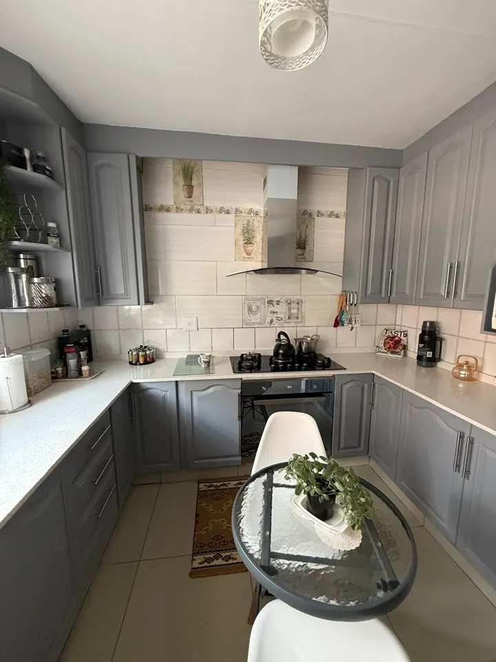 Grey shaker-style L-shaped kitchen with tiled splashback