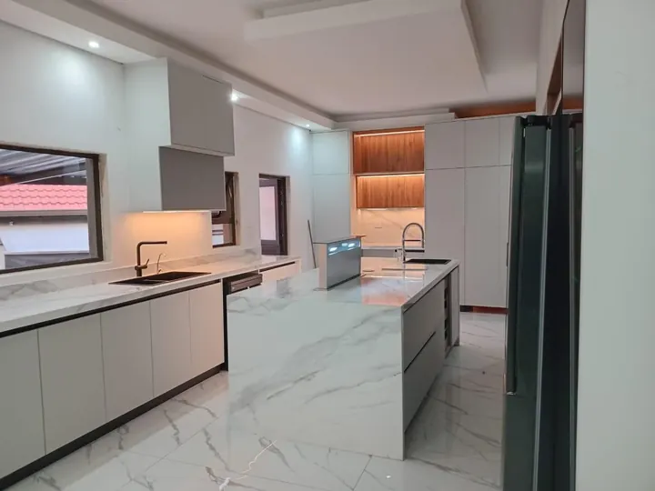 Modern white kitchen with marble-look waterfall island and timber-lit display niche