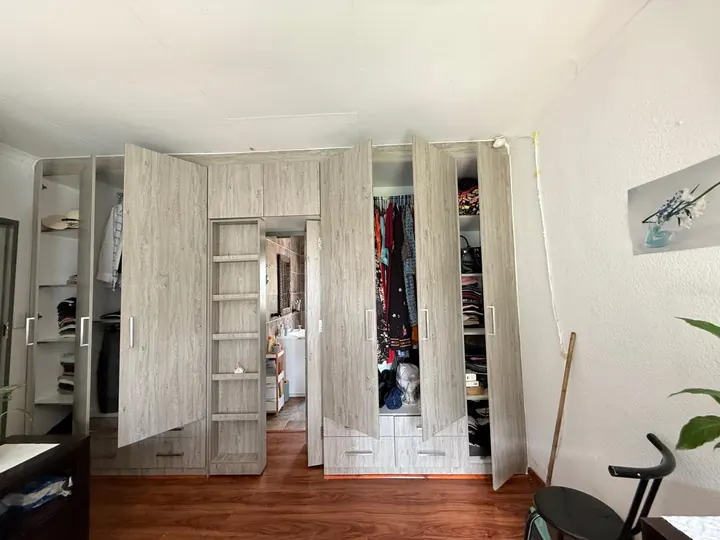 Built-in wardrobe with doors open showing hanging space and shelves