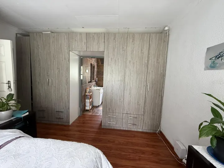 Wall of built-in wardrobes framing a doorway